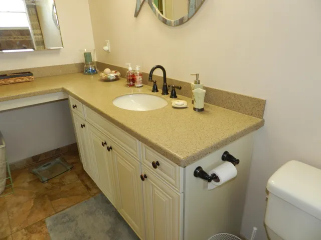 a bathroom with a sink a toilet and mirror