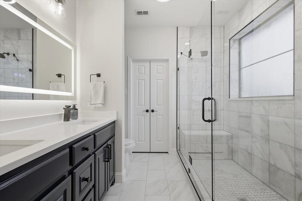 430 Ridgecrest Place Sanger, TX 76266 - Photo 15 of 40 Spacious bathroom featuring a dual vanity with dark cabinetry and quartz countertops
