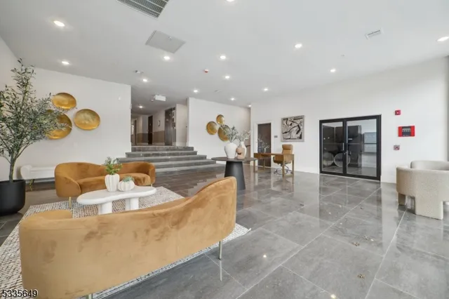 a living room with couches and kitchen view