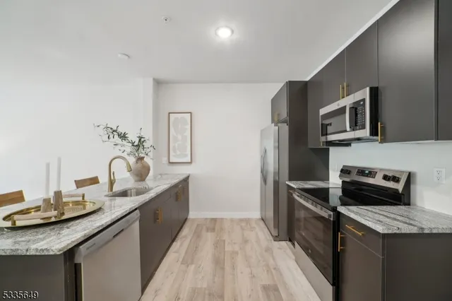 a kitchen with granite countertop stainless steel appliances and wooden cabinets