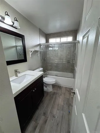 a bathroom with a sink a toilet a mirror and shower