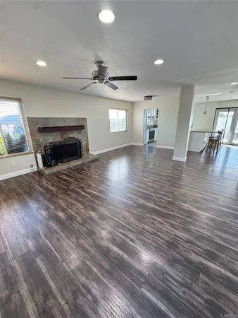 a view of empty room with wooden floor and fireplace