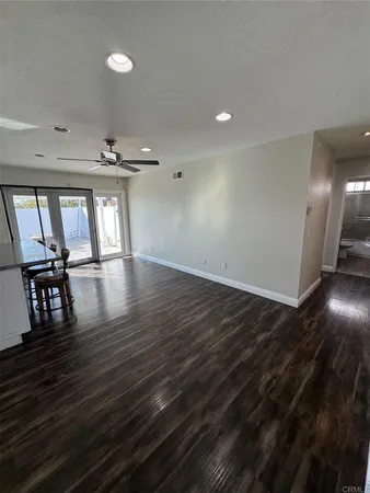a view of an empty room with window and wooden floor
