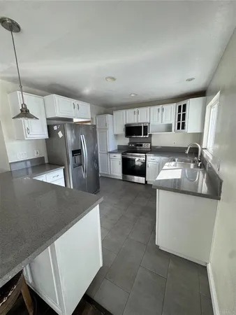 a kitchen with stainless steel appliances a sink a stove top oven a refrigerator and dishwasher