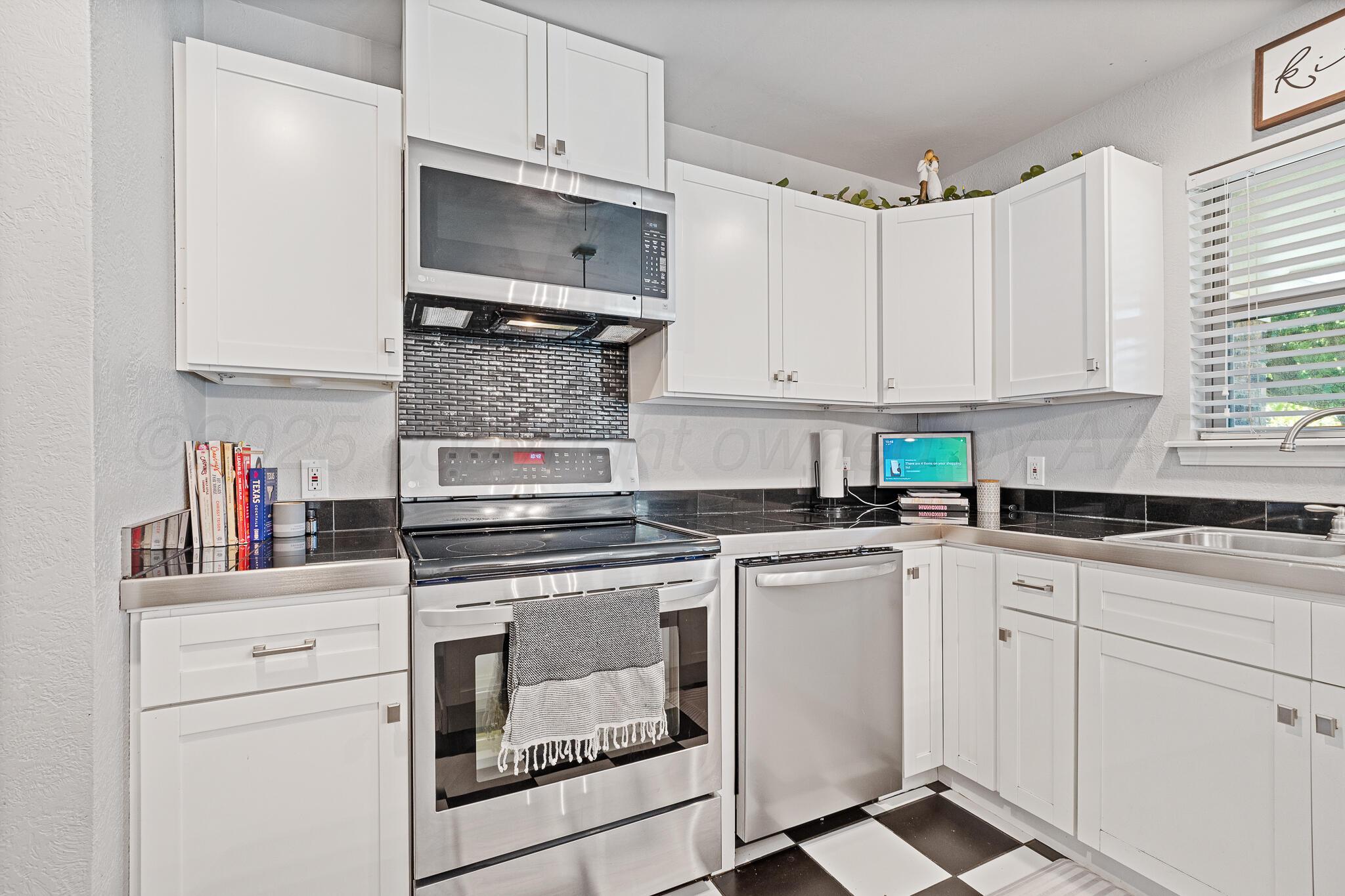 7602 Canode Drive Amarillo, TX 79121 - Photo 11 of 26 a kitchen with white cabinets and white appliances