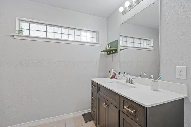a bathroom with a sink vanity and a mirror