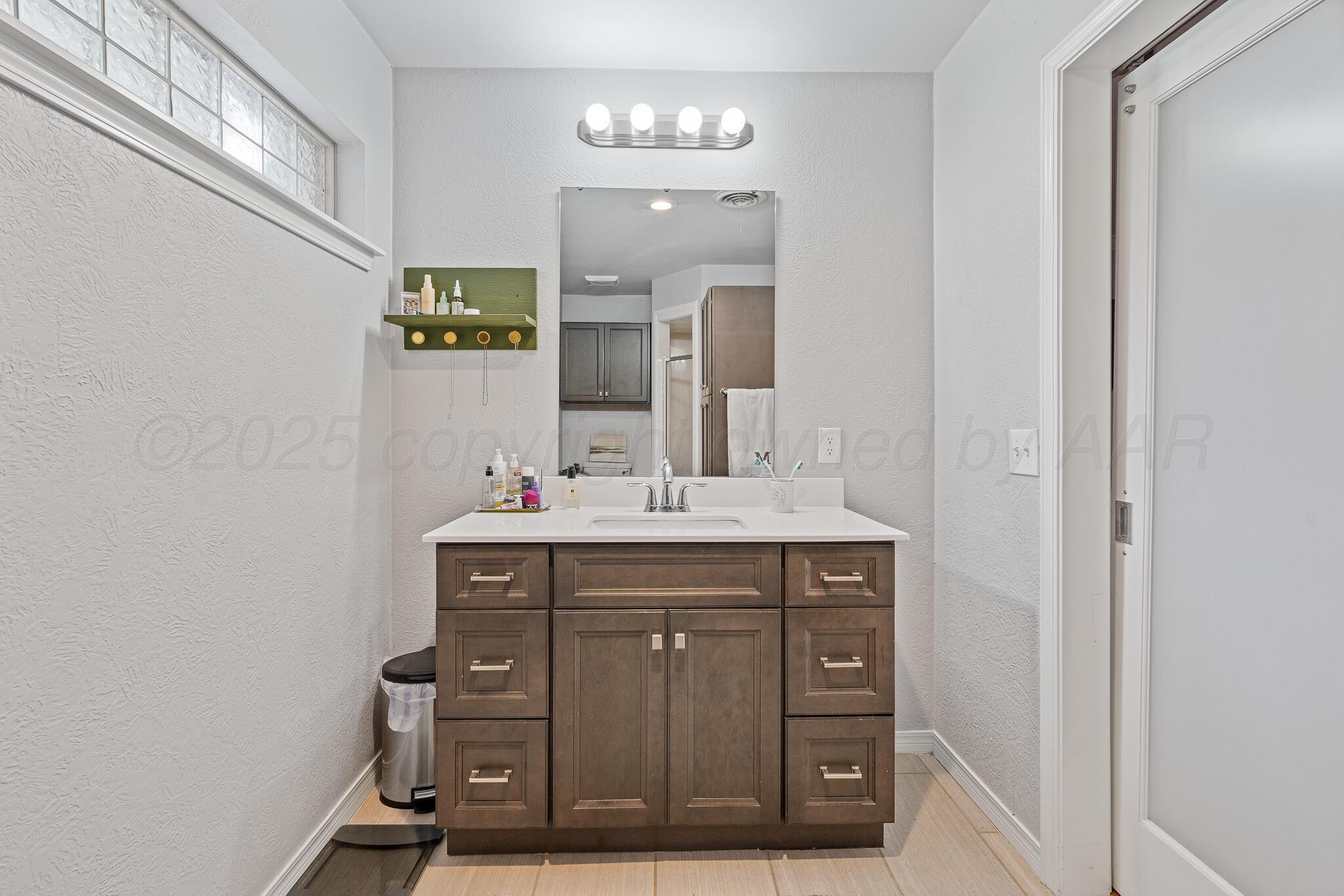 7602 Canode Drive Amarillo, TX 79121 - Photo 17 of 26 a bathroom with a sink and a mirror