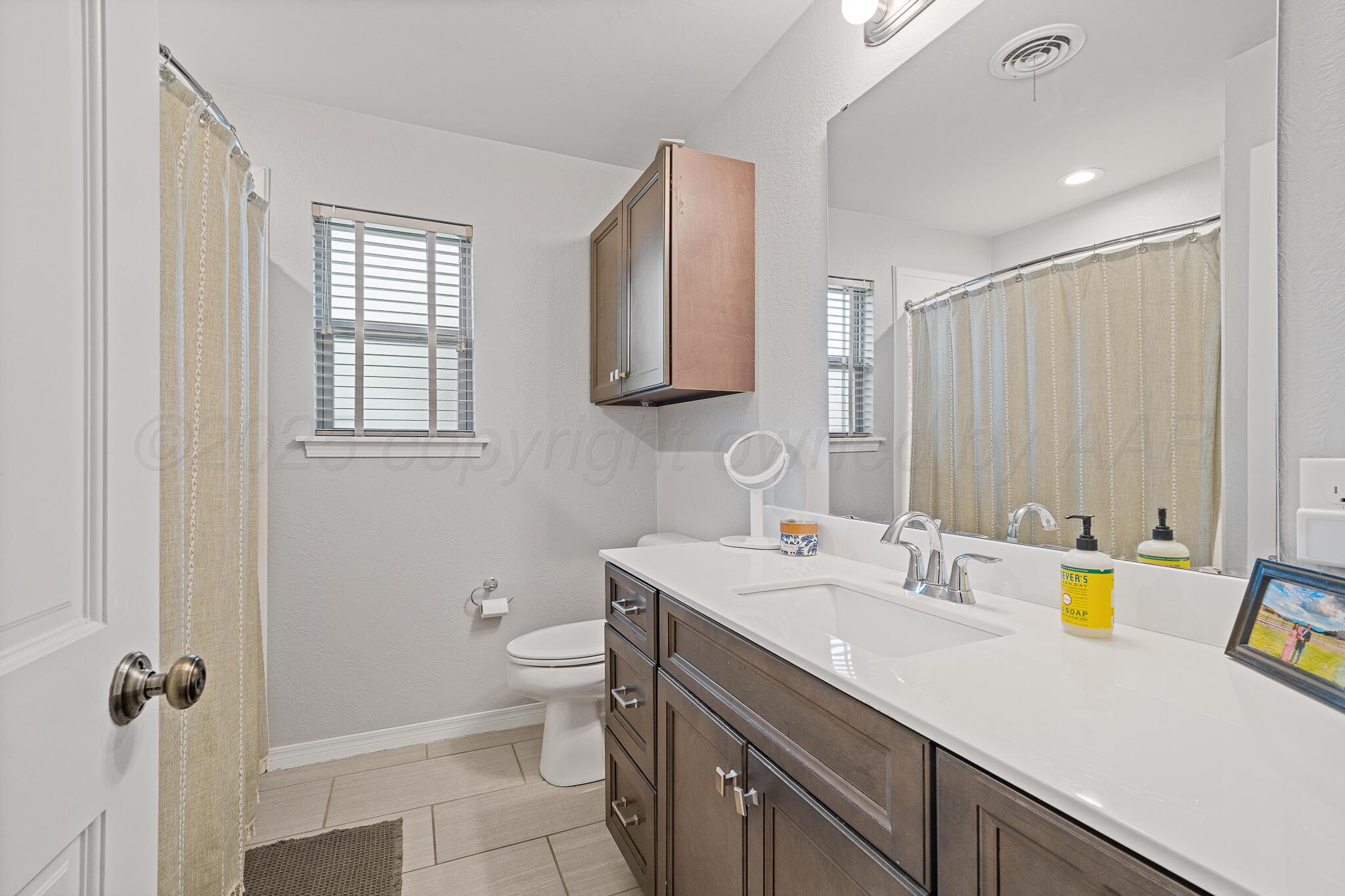 7602 Canode Drive Amarillo, TX 79121 - Photo 21 of 26 a bathroom with a sink a toilet and shower