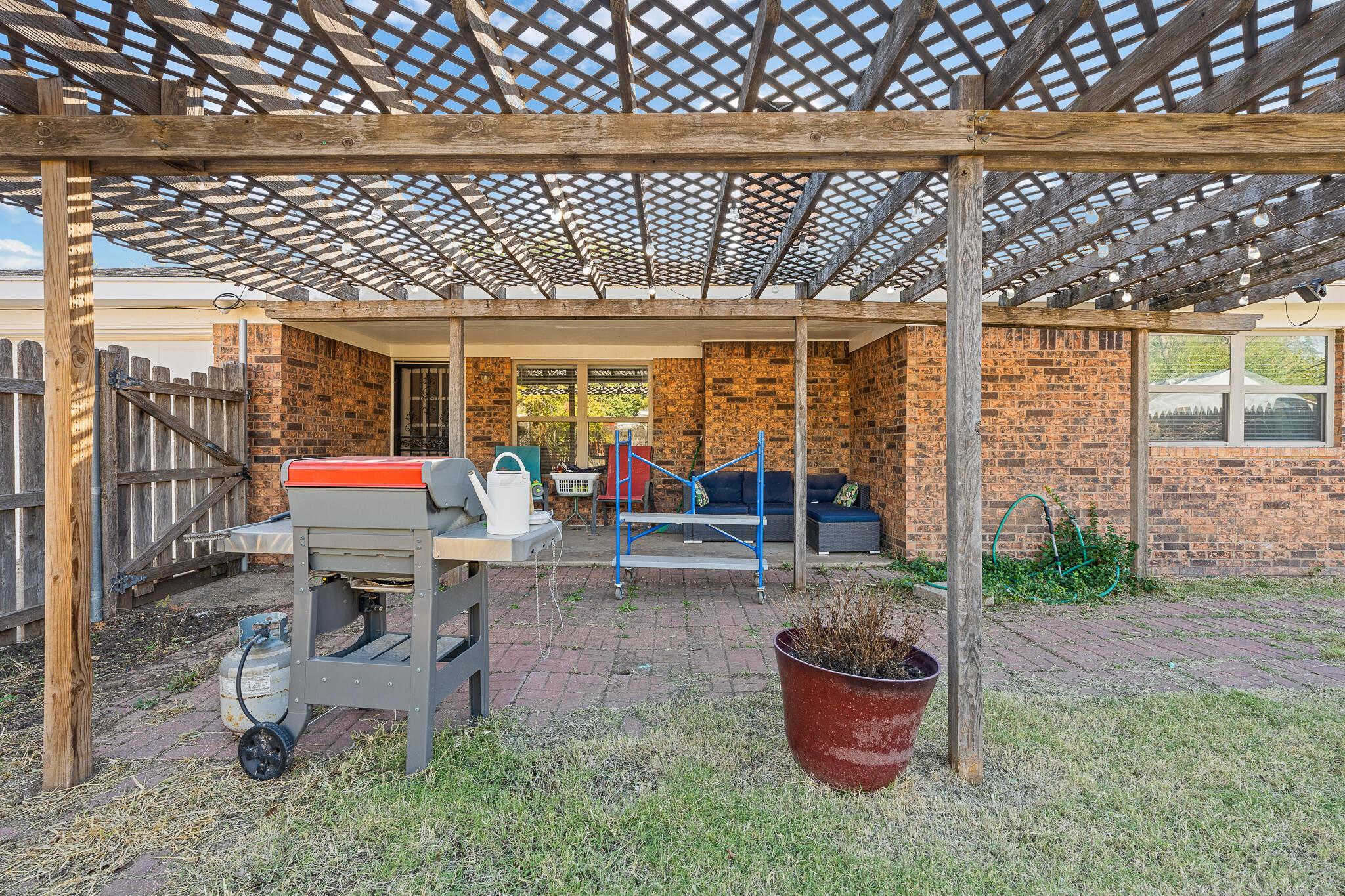 7602 Canode Drive Amarillo, TX 79121 - Photo 25 of 26 a view of a patio with a dining table and chairs and potted plants