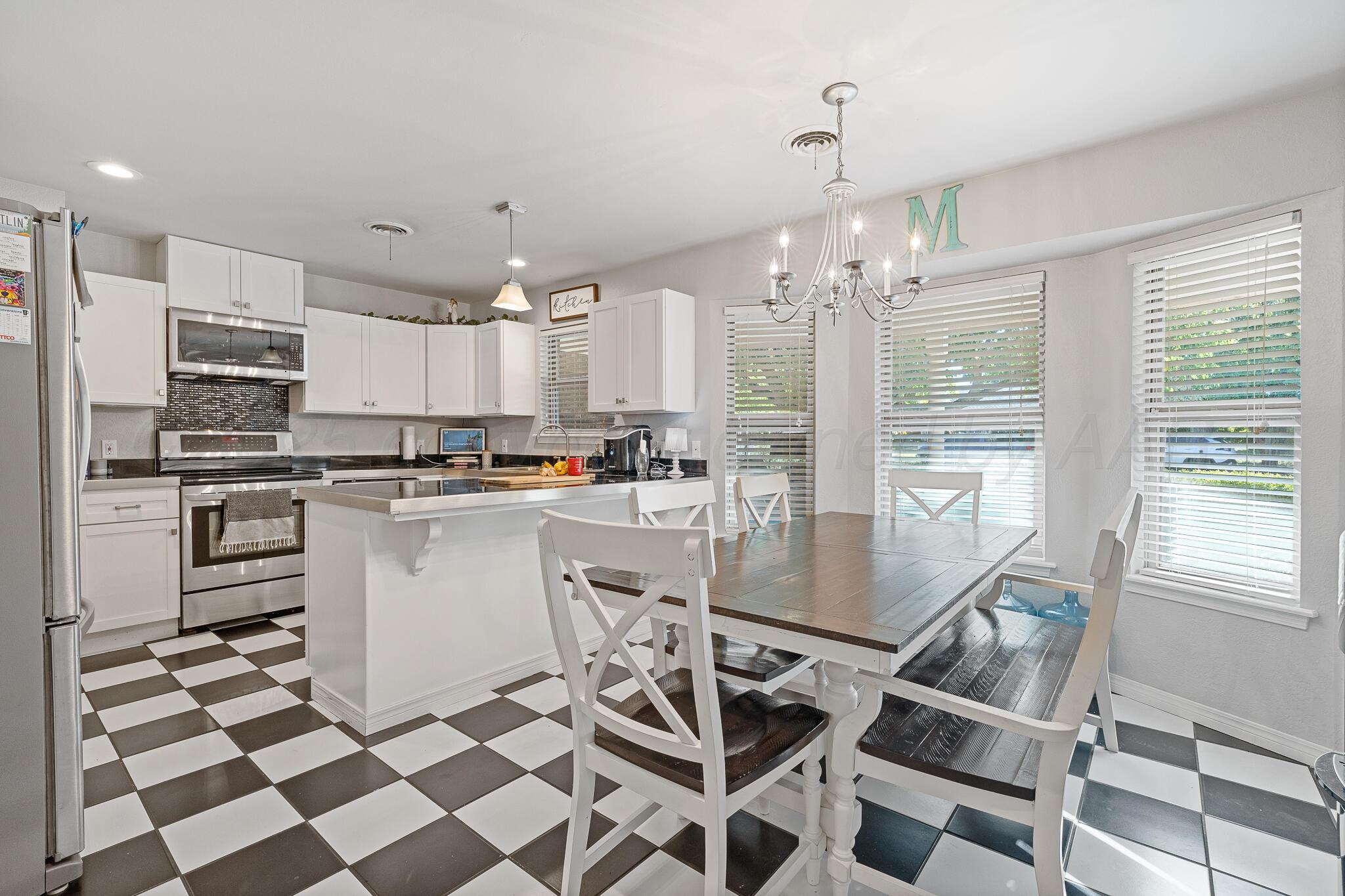7602 Canode Drive Amarillo, TX 79121 - Photo 9 of 26 a kitchen with a refrigerator a sink and cabinets
