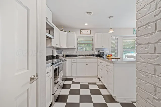 a kitchen with a checkered floor and white cabinets