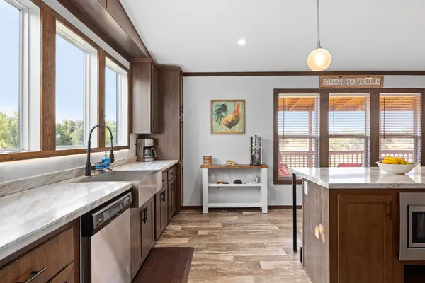 a large kitchen with granite countertop a large window and a sink