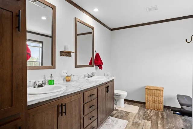 a bathroom with a granite countertop sink mirror vanity and toilet