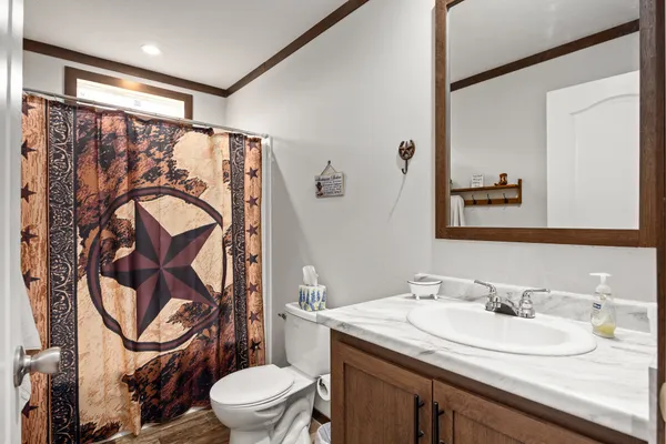a bathroom with a granite countertop sink a toilet and a mirror