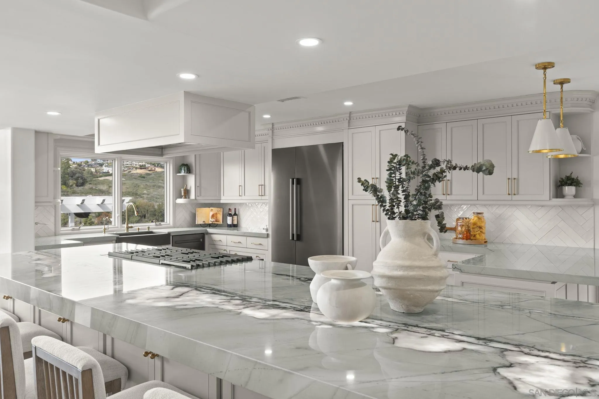 1542 El Paso Real La Jolla, CA 92037 - Photo 9 of 30 a kitchen with stainless steel appliances kitchen island granite countertop a refrigerator and a sink