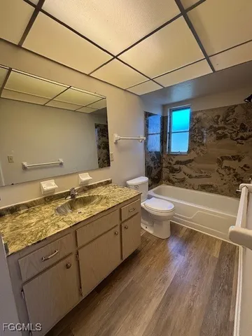 a bathroom with a granite countertop sink mirror vanity and toilet