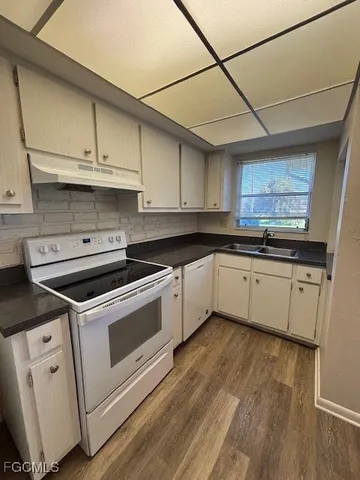 a white kitchen with sink and cabinets