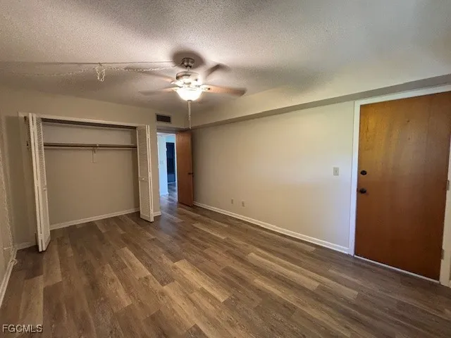 a view of an empty room with closet and a window