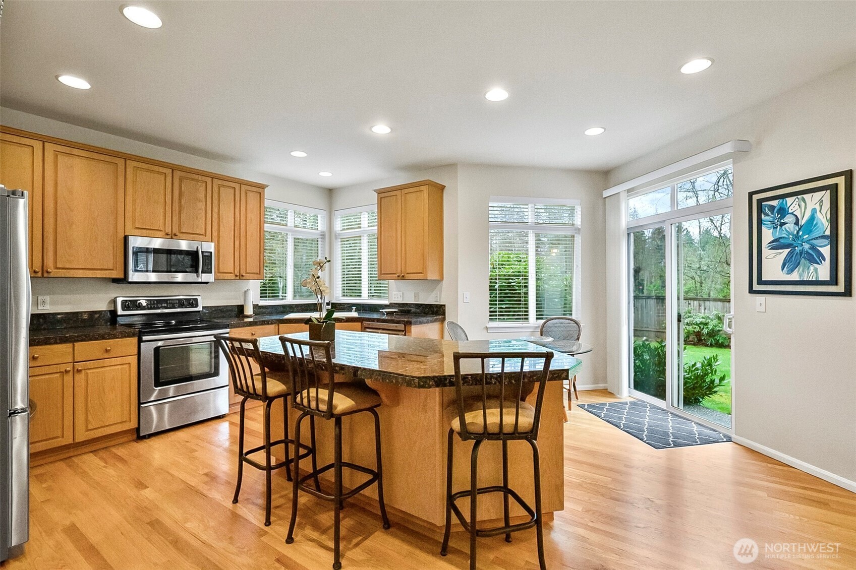 17401 33rd Drive Southeast Bothell, WA 98012 - Photo 11 of 39 a kitchen with stainless steel appliances granite countertop wooden floor dining table and chairs