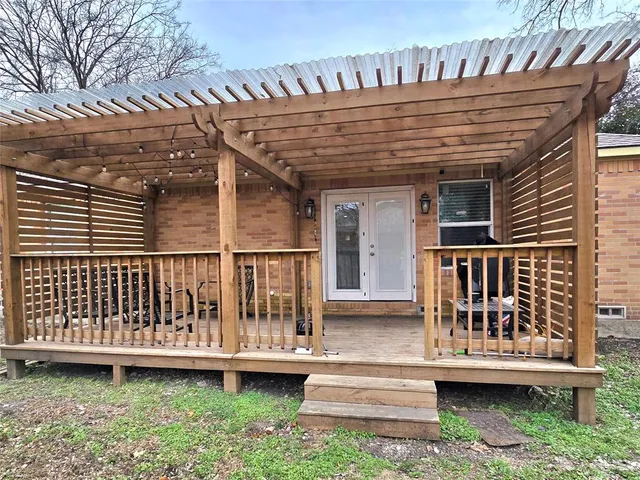 a view of a house with wooden deck and furniture