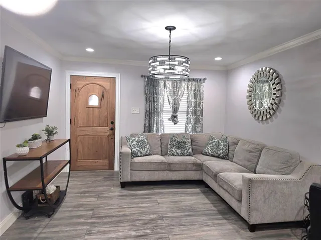 a living room with furniture and a chandelier