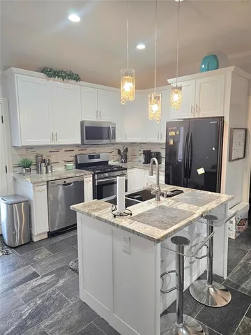 a kitchen with a stove a sink and a refrigerator