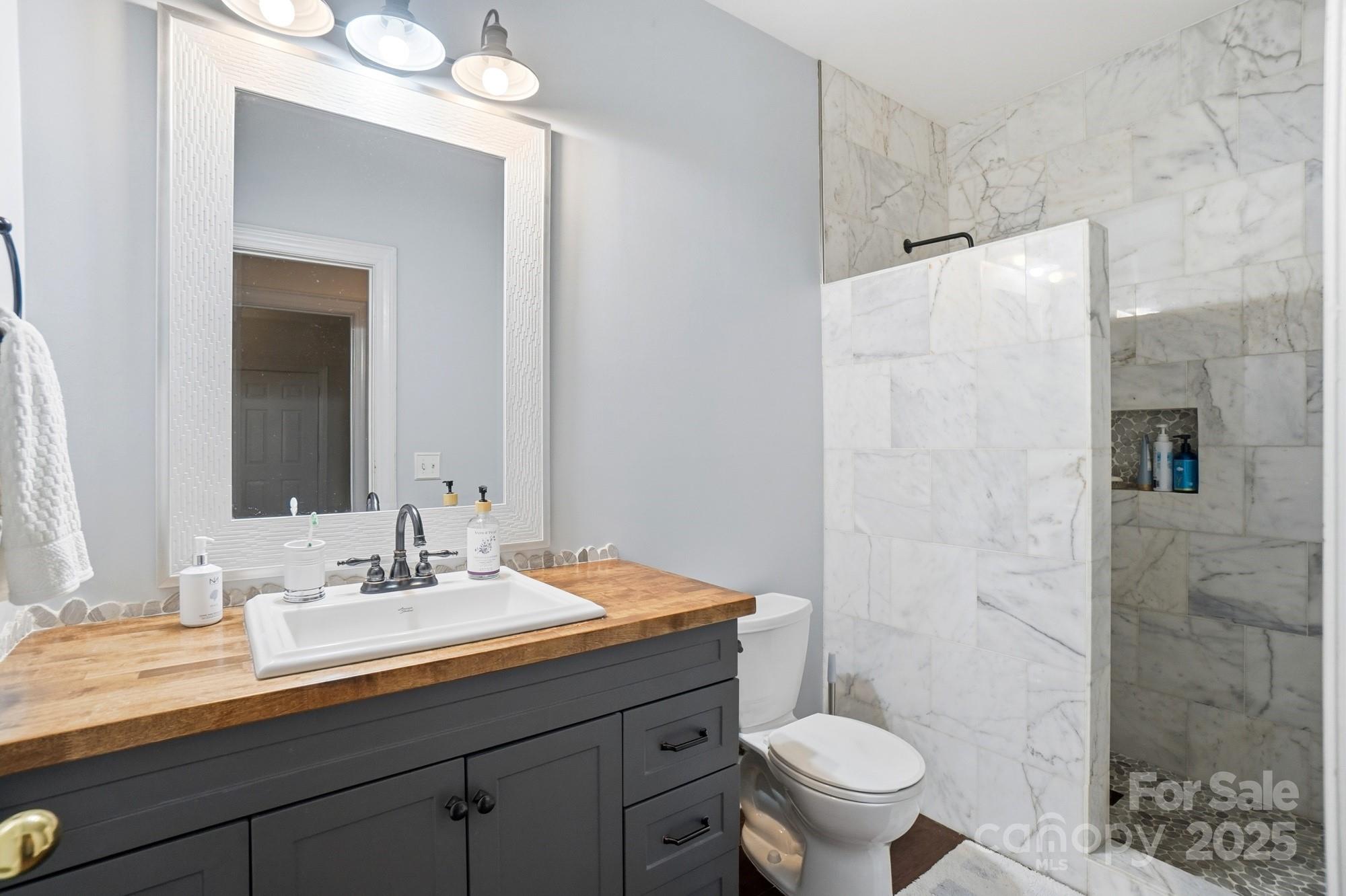 5617 Fairview Road, Unit 5 Charlotte, NC 28209 - Photo 21 of 26 a bathroom with a sink toilet and shower