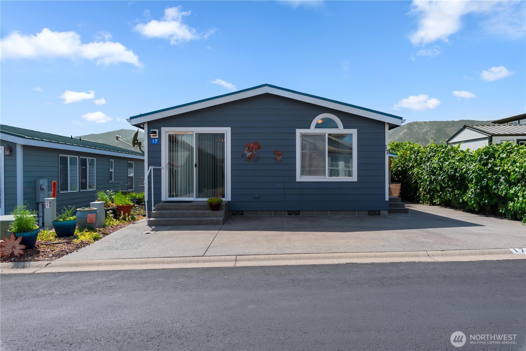 1000 Highway 150, Unit 17 Manson, WA 98831 - Photo 1 of 15 a front view of a house with a yard and potted plants