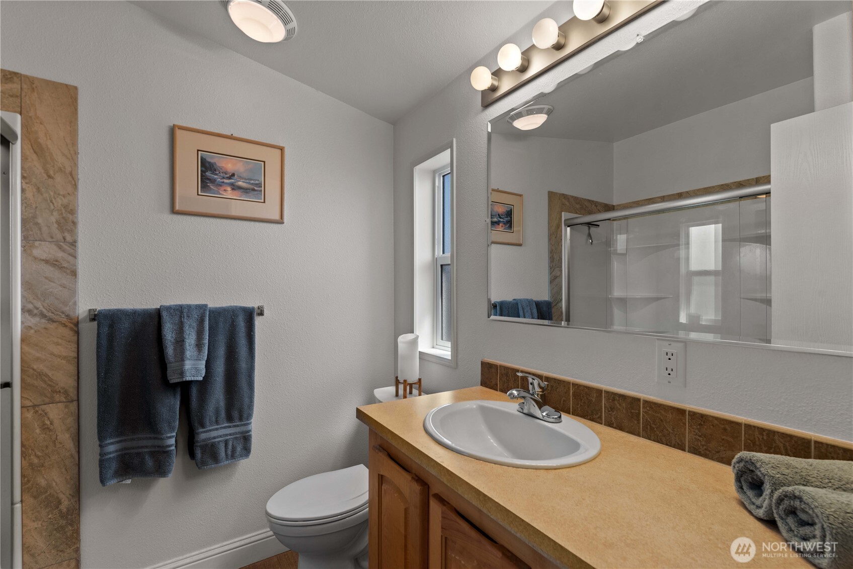 1000 Highway 150, Unit 17 Manson, WA 98831 - Photo 12 of 15 a bathroom with a granite countertop toilet a sink and a large mirror