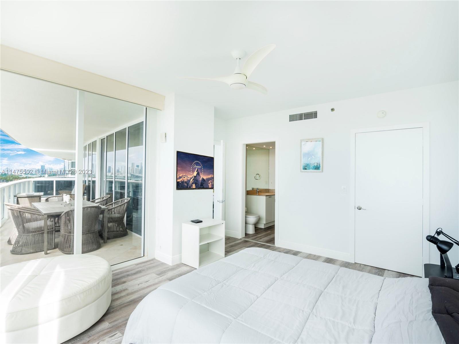 400 Alton Road, Unit 1104 Miami Beach, FL 33139 - Photo 8 of 27 a spacious bedroom with a bed and a view of kitchen