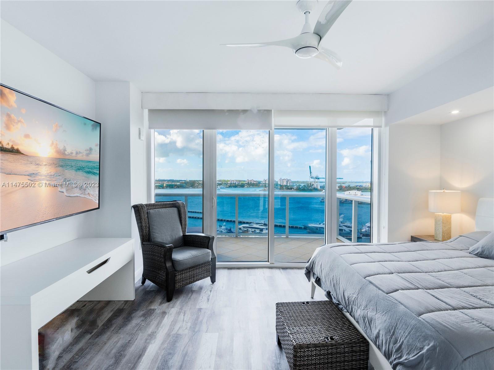 400 Alton Road, Unit 1104 Miami Beach, FL 33139 - Photo 10 of 27 a bedroom with a bed and large windows