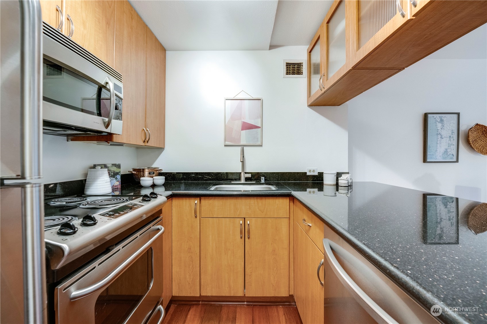 1105 Spring Street, Unit 309 Seattle, WA 98104 - Photo 11 of 39 a kitchen with stainless steel appliances granite countertop a sink and a stove