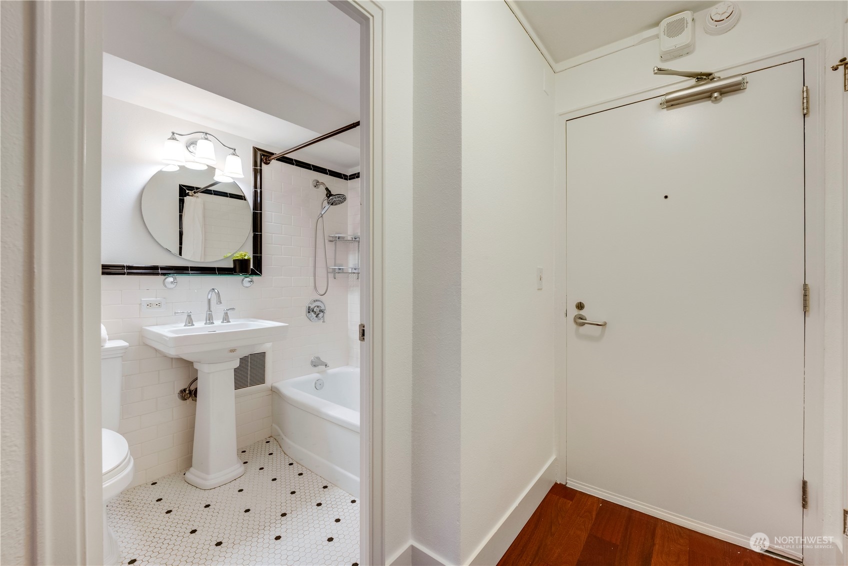 1105 Spring Street, Unit 309 Seattle, WA 98104 - Photo 23 of 39 a bathroom with a sink a toilet and mirror