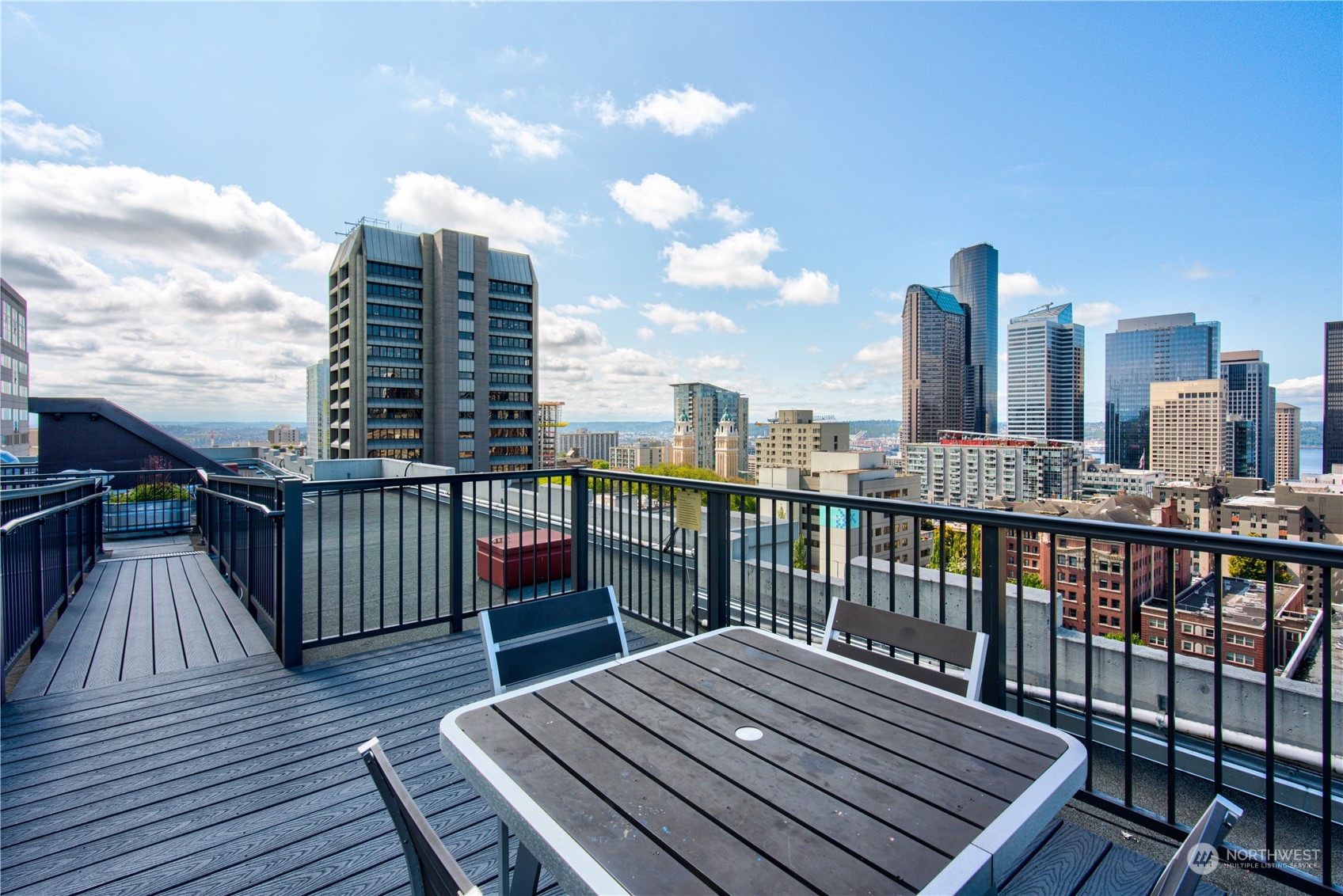 1105 Spring Street, Unit 309 Seattle, WA 98104 - Photo 27 of 39 a view of a roof deck with two couches and wooden floor