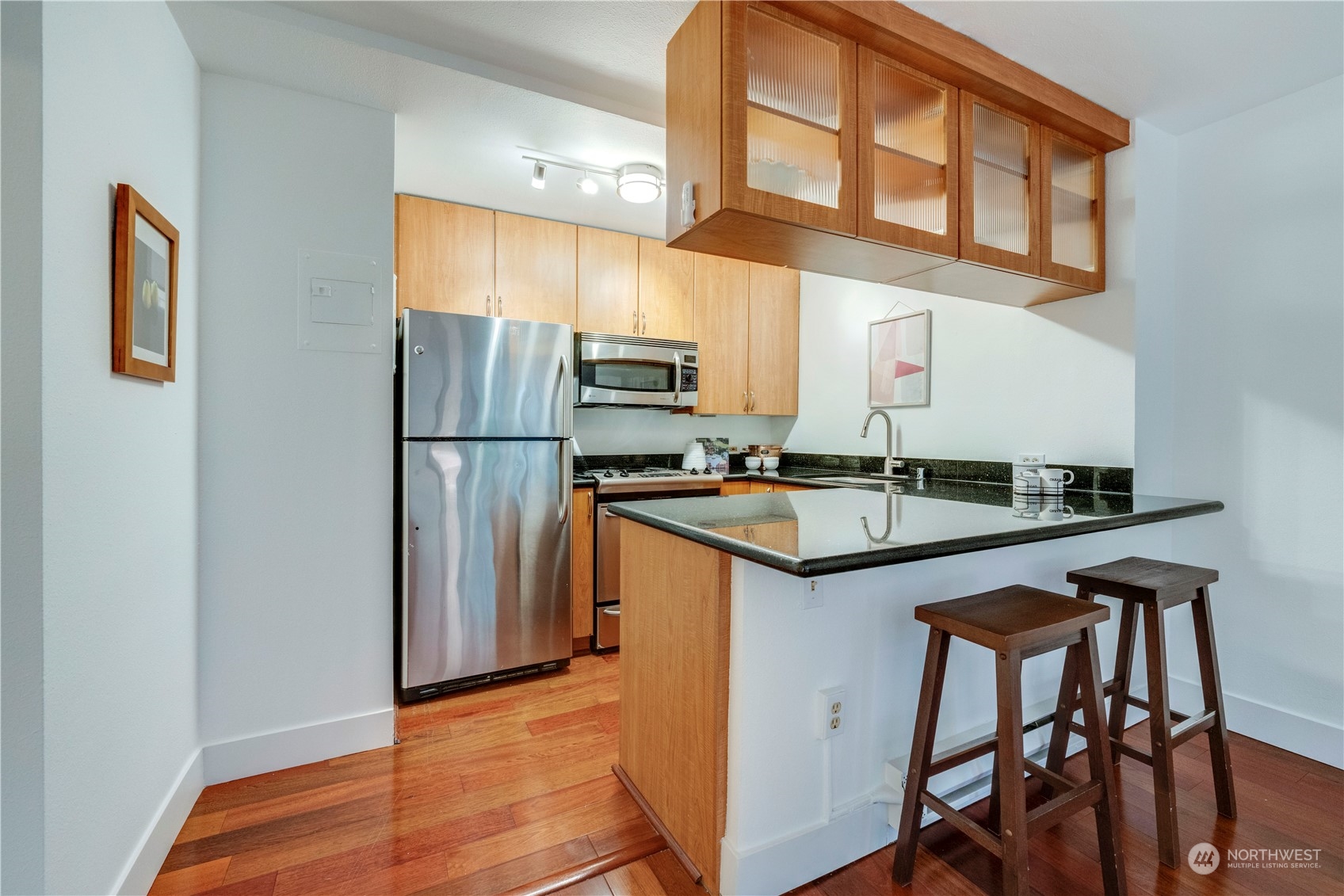 1105 Spring Street, Unit 309 Seattle, WA 98104 - Photo 5 of 39 a kitchen with stainless steel appliances granite countertop a refrigerator a sink and a stove