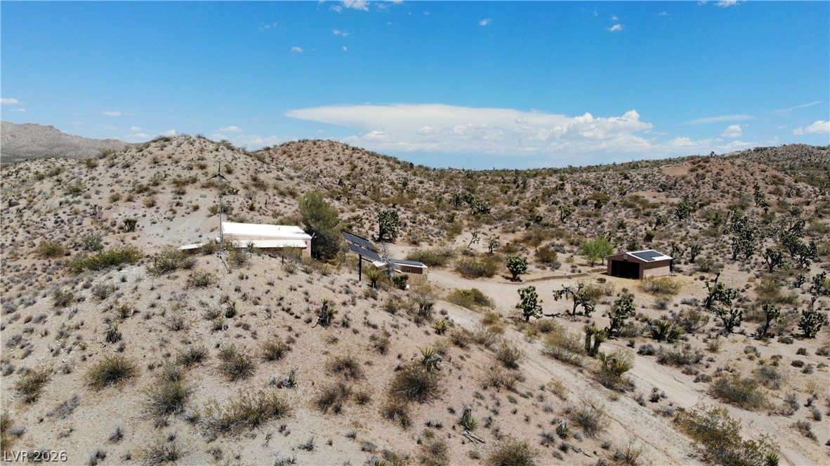 Rocking S Ranch Road Searchlight, NV 89046 - Photo 3 of 47 Perched on a sun-drenched desert hillside, this remote dwelling offers panoramic views and a tranquil, expansive environment.