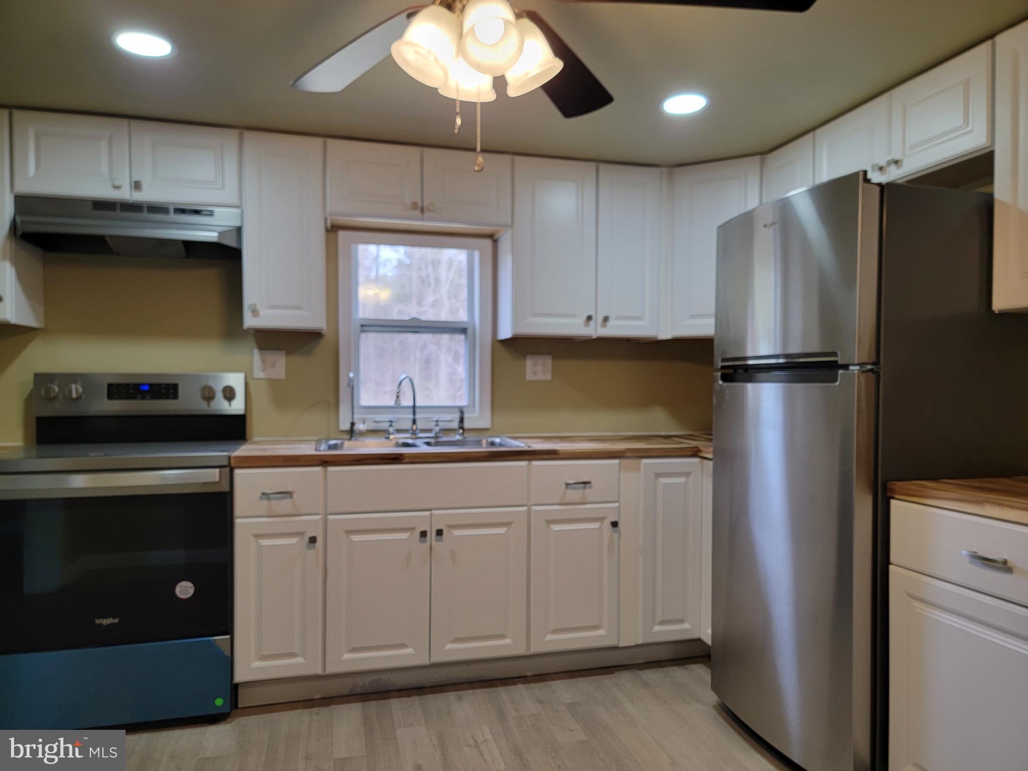 5047 Back Shelltown Road Marion Station, MD 21838 - Photo 11 of 20 a kitchen with stainless steel appliances granite countertop a refrigerator a stove a sink and a microwave oven
