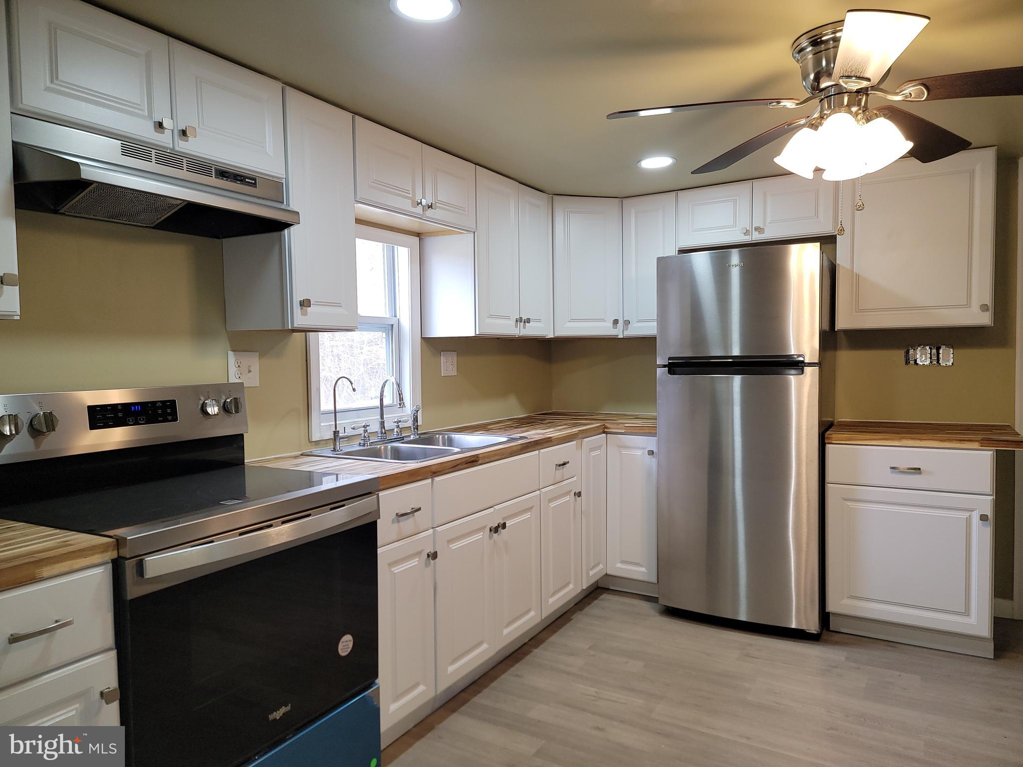 5047 Back Shelltown Road Marion Station, MD 21838 - Photo 12 of 20 a kitchen with a refrigerator sink and cabinets