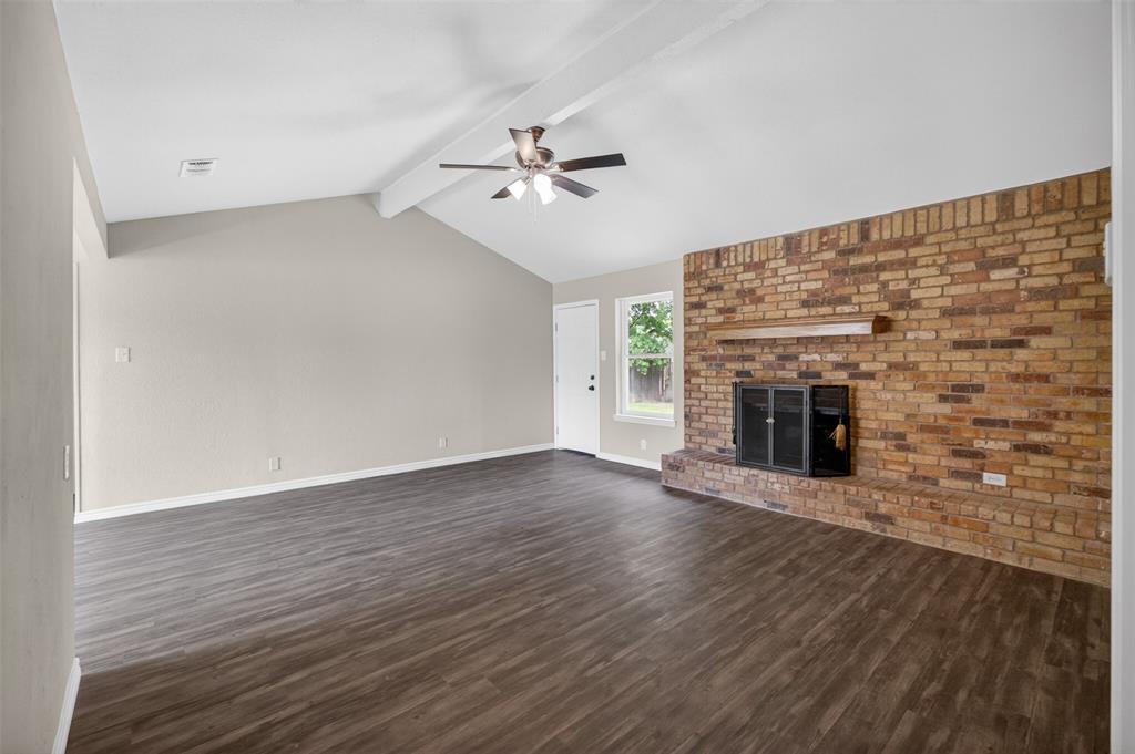 7528 Meadowlark Lane North Watauga, TX 76148 - Photo 6 of 31 an empty room with wooden floor fireplace and fan