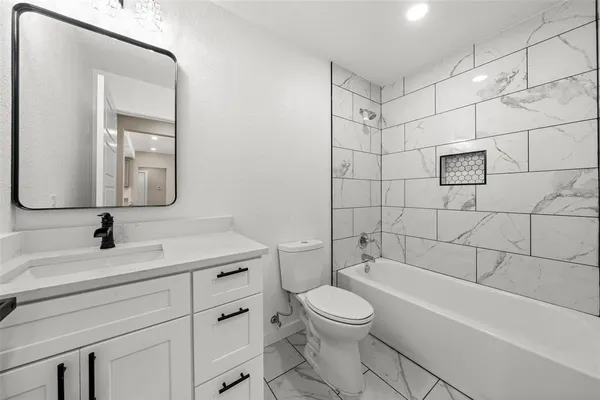 a bathroom with a toilet sink vanity shower and mirror