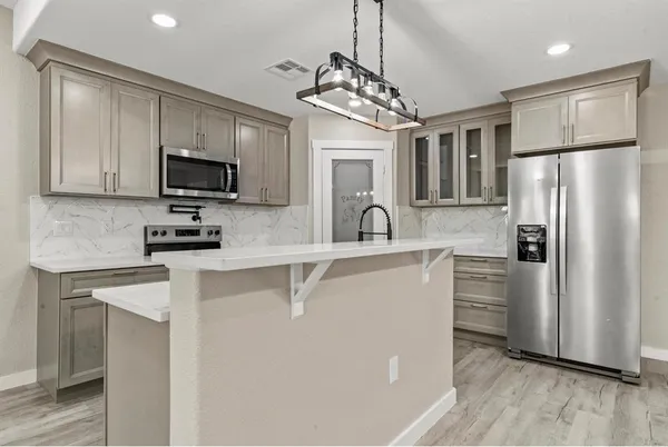 a kitchen with stainless steel appliances a refrigerator sink and microwave