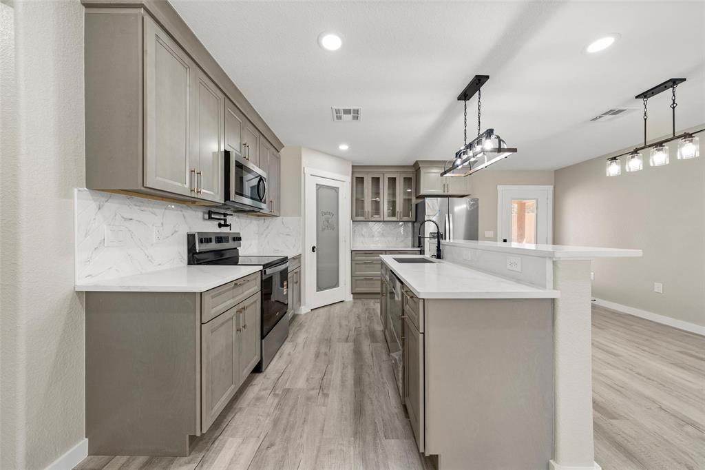 2509 Stewart Drive Waco, TX 76708 - Photo 5 of 17 a kitchen with stainless steel appliances kitchen island a large counter space a sink and a refrigerator