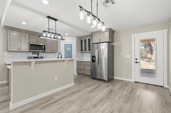 a view of a kitchen with a refrigerator a microwave oven a sink and a refrigerator
