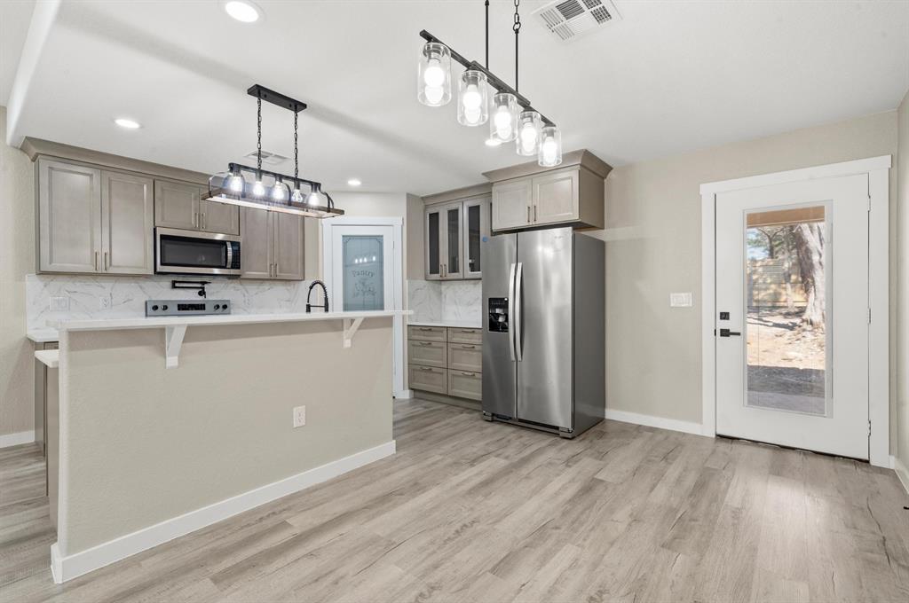 2509 Stewart Drive Waco, TX 76708 - Photo 6 of 17 a view of a kitchen with a refrigerator a microwave oven a sink and a refrigerator