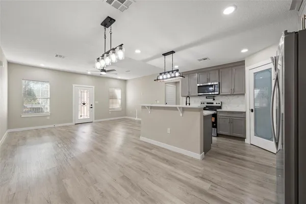 a view of a kitchen with a sink dishwasher stove top oven and refrigerator