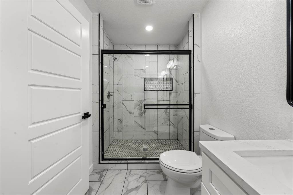 2509 Stewart Drive Waco, TX 76708 - Photo 10 of 17 a bathroom with a granite countertop toilet a sink and a shower