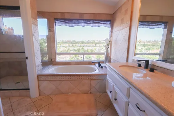 a spacious bathroom with a tub sink and mirror