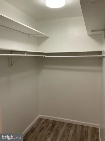 a view of a big room with wooden floor and windows