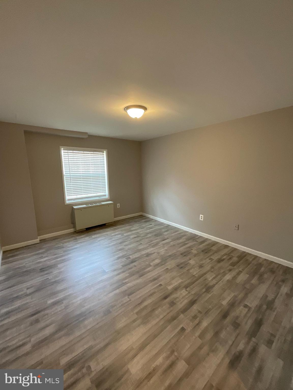 4509 Romlon Street, Unit 102 Beltsville, MD 20705 - Photo 19 of 22 an empty room with wooden floor and windows
