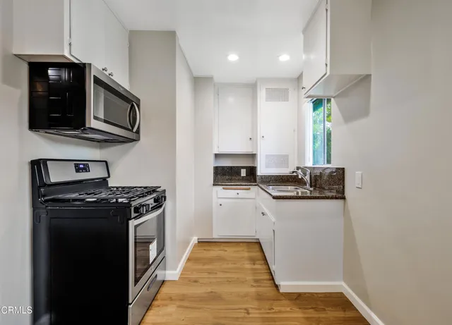 a kitchen with stainless steel appliances granite countertop a stove and a microwave